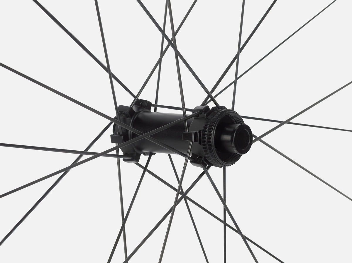 Close-up of Litebike Arc-35 carbon wheelset with a black bicycle wheel hub with thin black spokes radiating against a light gray background.